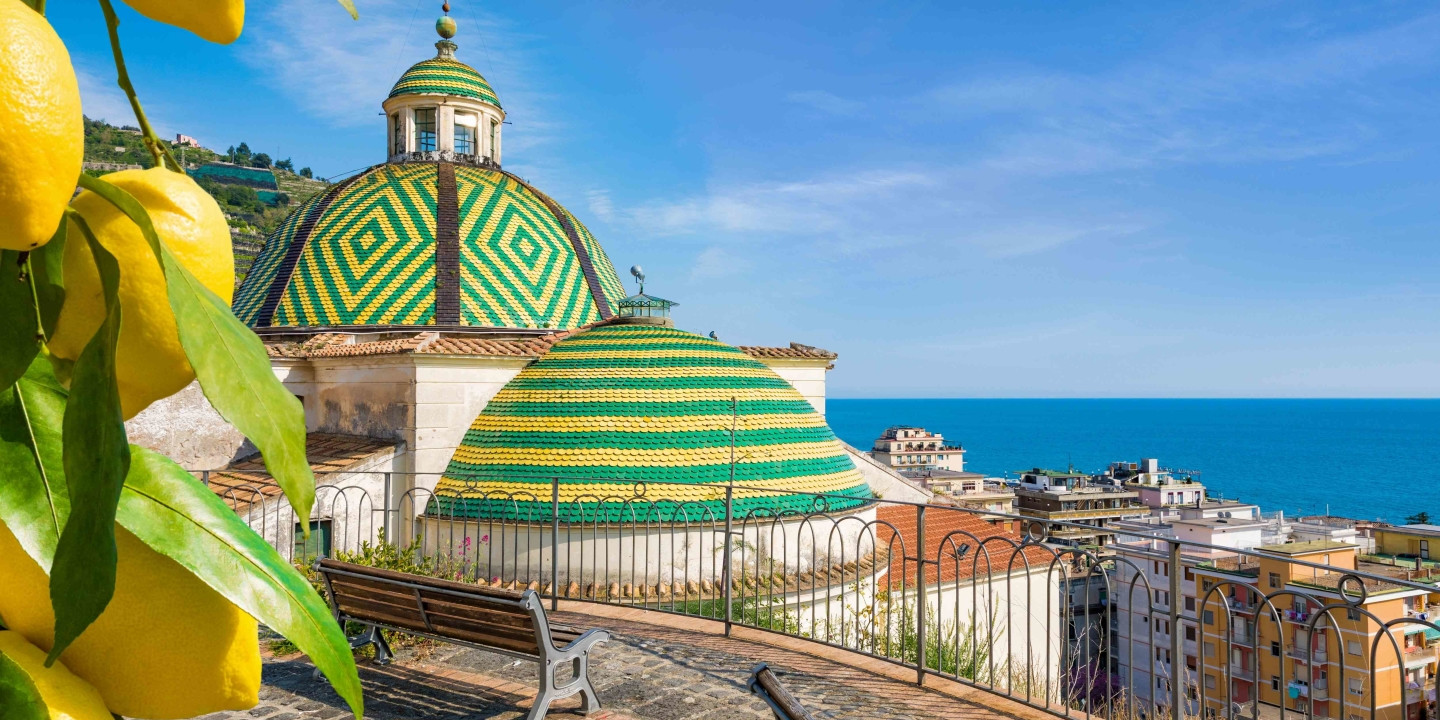Chiesa di Santa Maria a Mare a Maiori con cupola piastrellata colorata e vista sul mare della Costiera Amalfitana.