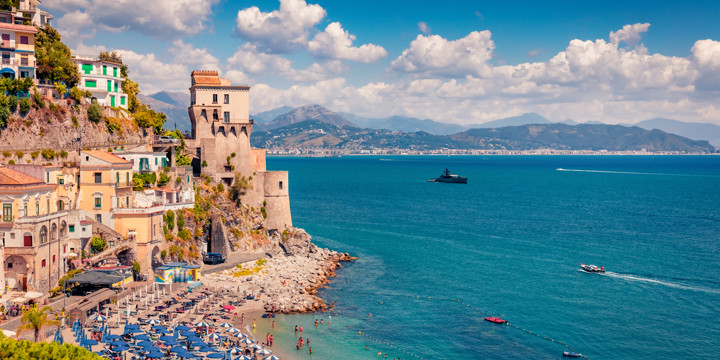 Panoramic view of the picturesque village of Cetara, featuring its historic watchtower, Torre Vicereale, pebble beach, and turquoise sea