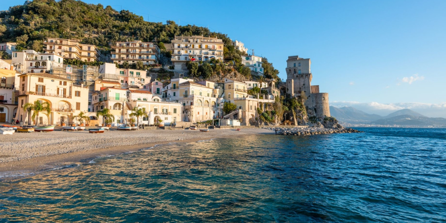 Panoramic view of Cetara village on the Amalfi Coast, featuring the beach and the historic Viceregal tower during a sunny day