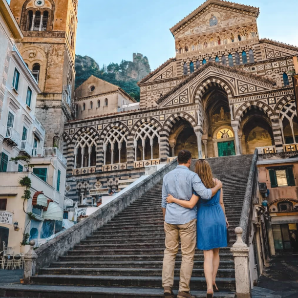 Couple walking up the steps of Amalfi Cathedral during a romantic guided tour along the Amalfi Coast, surrounded by history and medieval architecture.