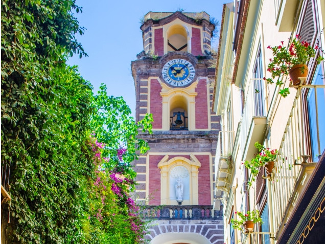 Bell tower in Sorrento historic center surrounded by narrow streets and buildings