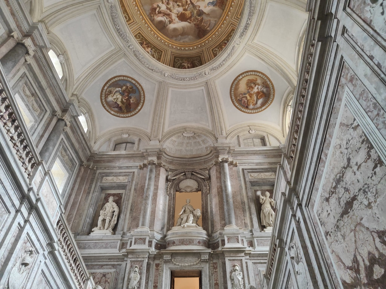 The monumental hall of the Royal Palace of Caserta with columns, statues and marble decoration