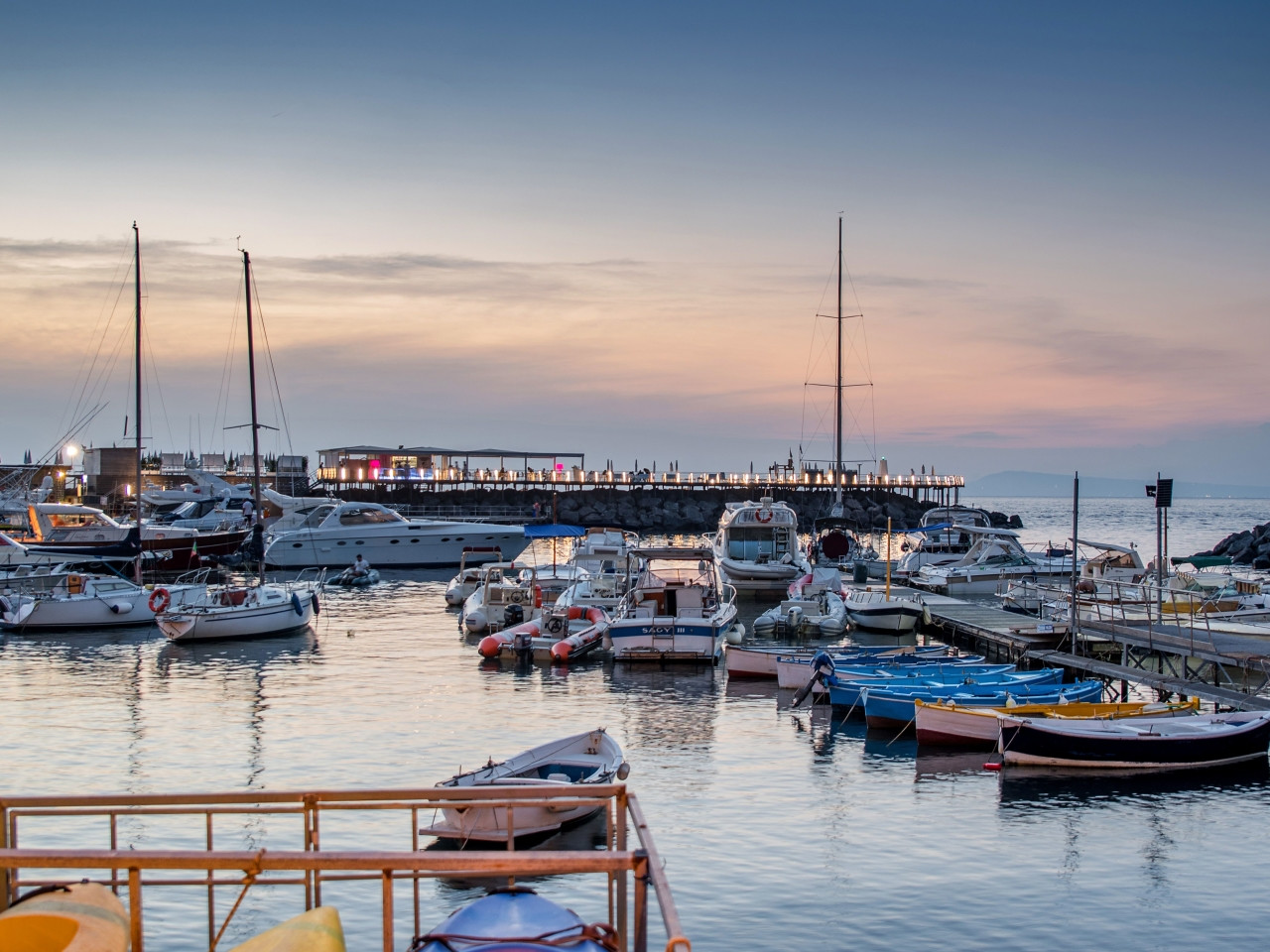 The marina of Seiano at sunset, with boats moored in the harbour of Vico Equense