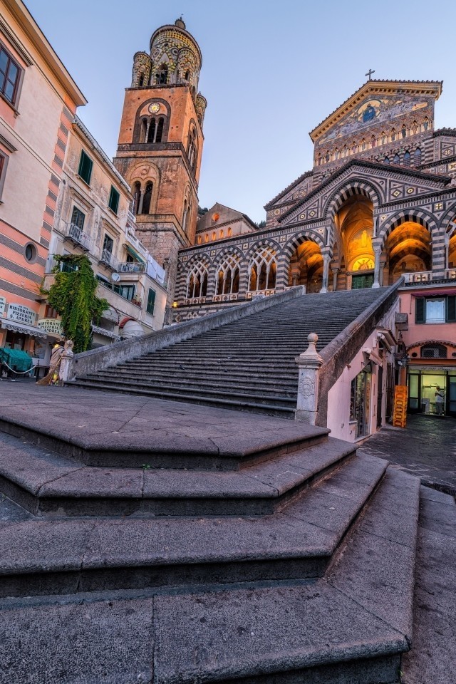Low-angle view of the monumental staircase leading to the Amalfi Cathedral during the blue hour at dusk